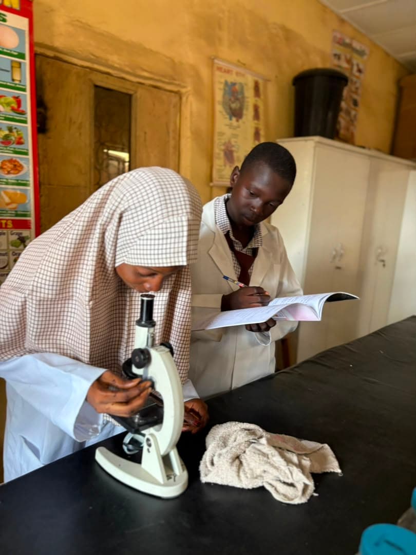 Students examining a specimen under the microscope